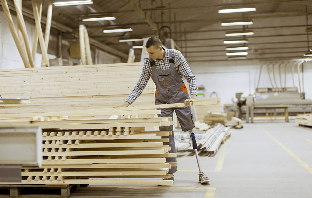 Photo of a man with prosthetic leg working in furniture factory