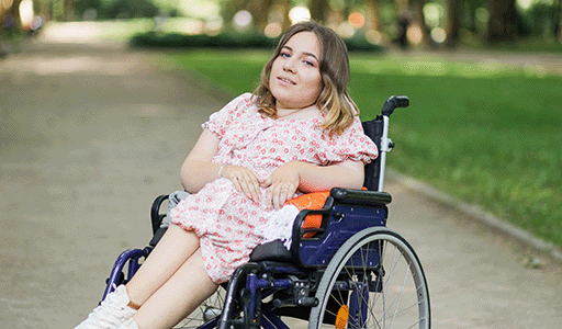 Woman with an intellectual impairment feeding her dog a treat with the help of her support worker.